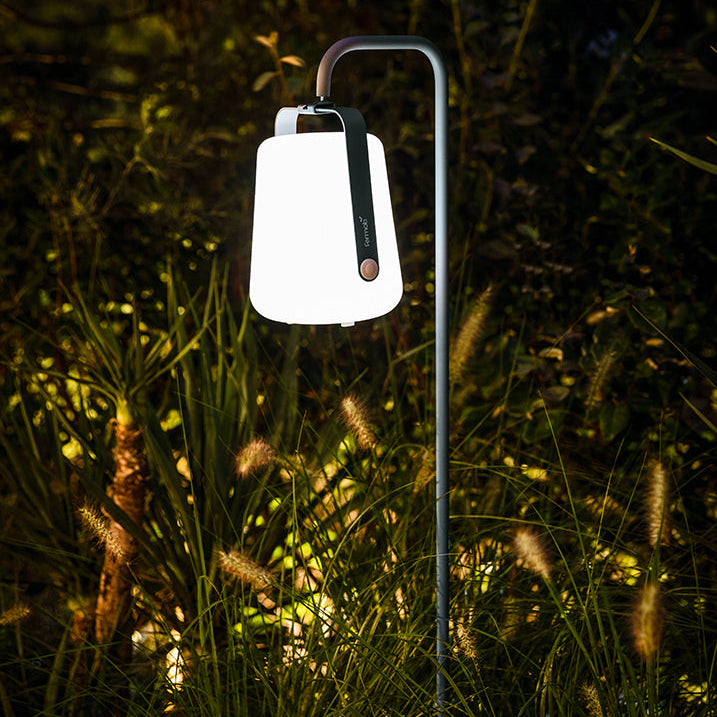 Garden lamp illuminating a dark GARDEN with grass and trees in the background