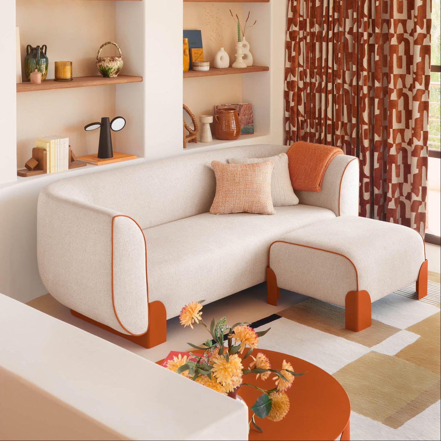 Modern living room with a beige sofa, orange coffee table, and decorative shelves.
