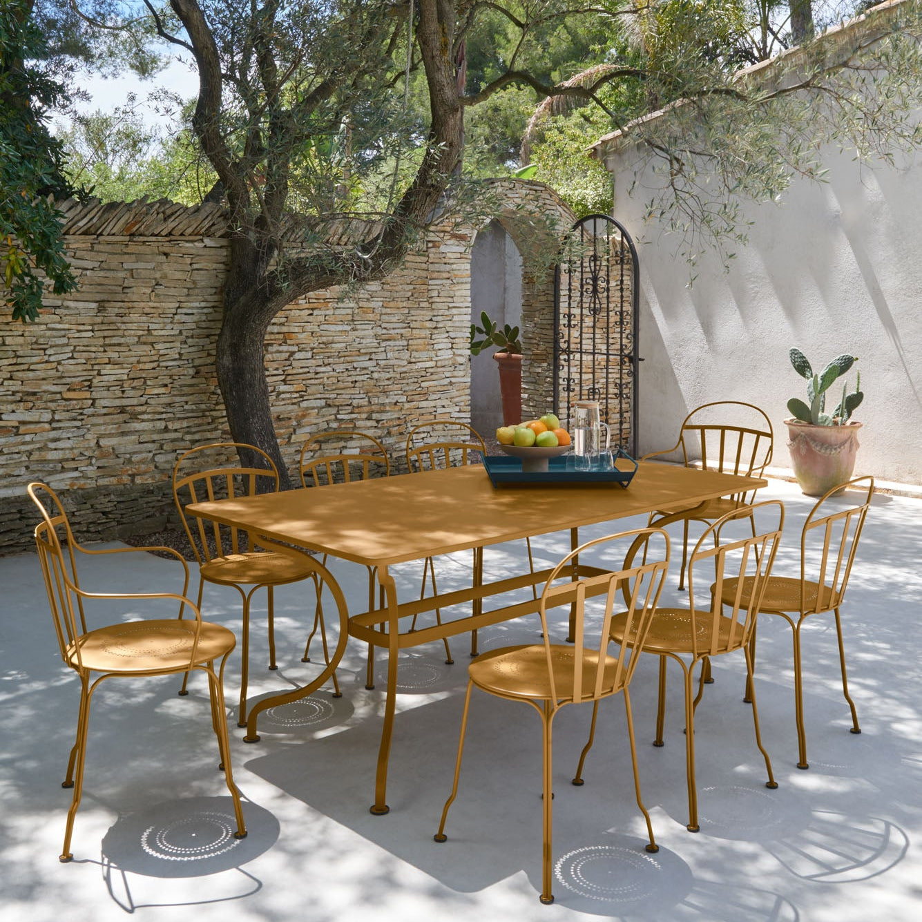Outdoor dining area with metal table and chairs under a tree