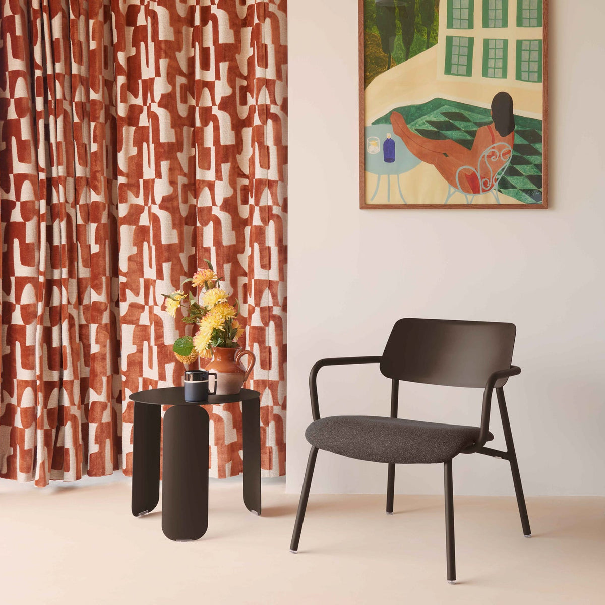Modern interior with a patterned curtain, chair, and side table.
