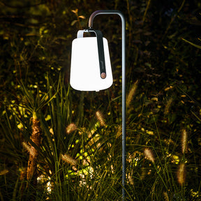 Garden lamp illuminating a dark GARDEN with grass and trees in the background