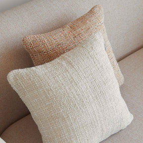 Two textured pillows on a beige sofa