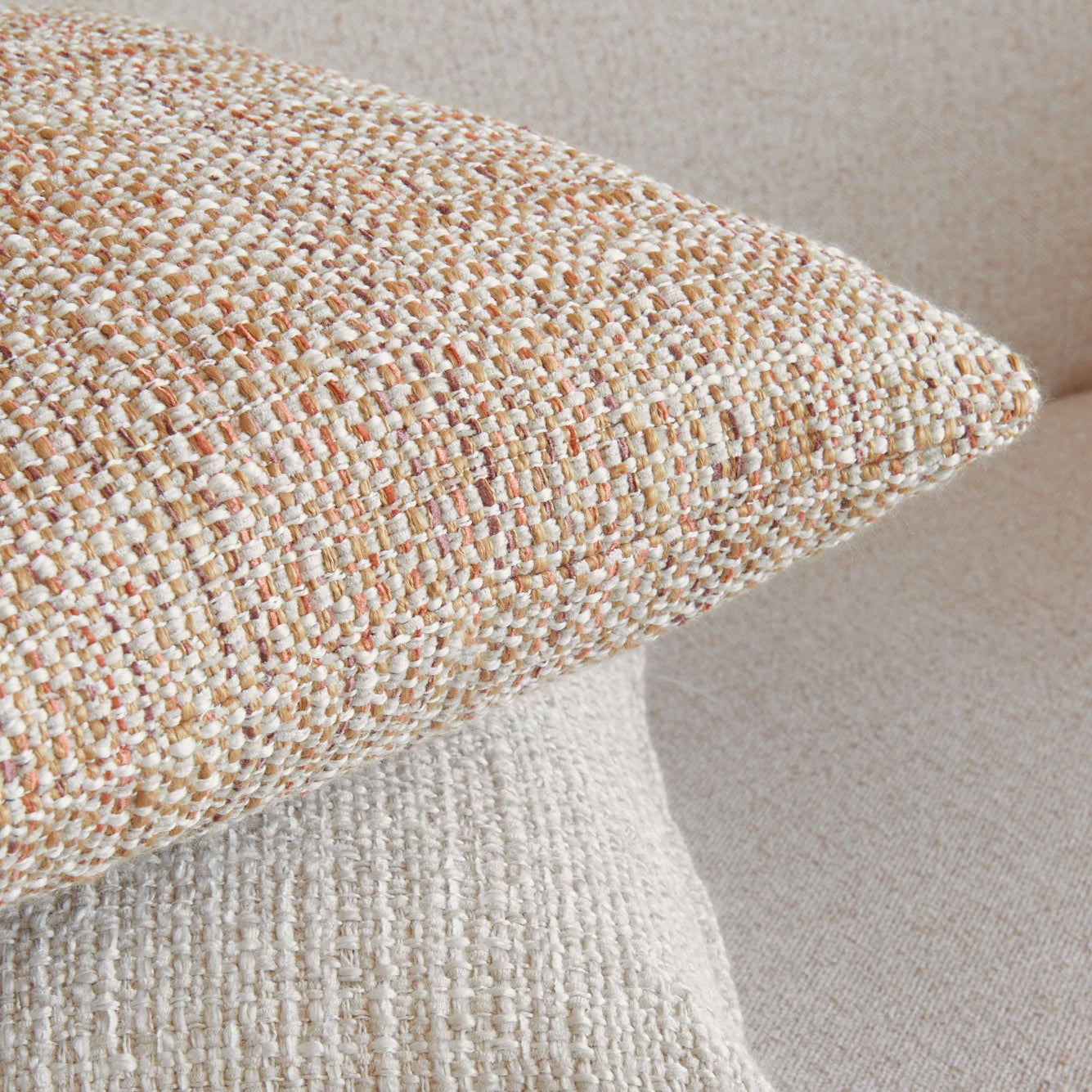 Two textured pillows stacked on a neutral background